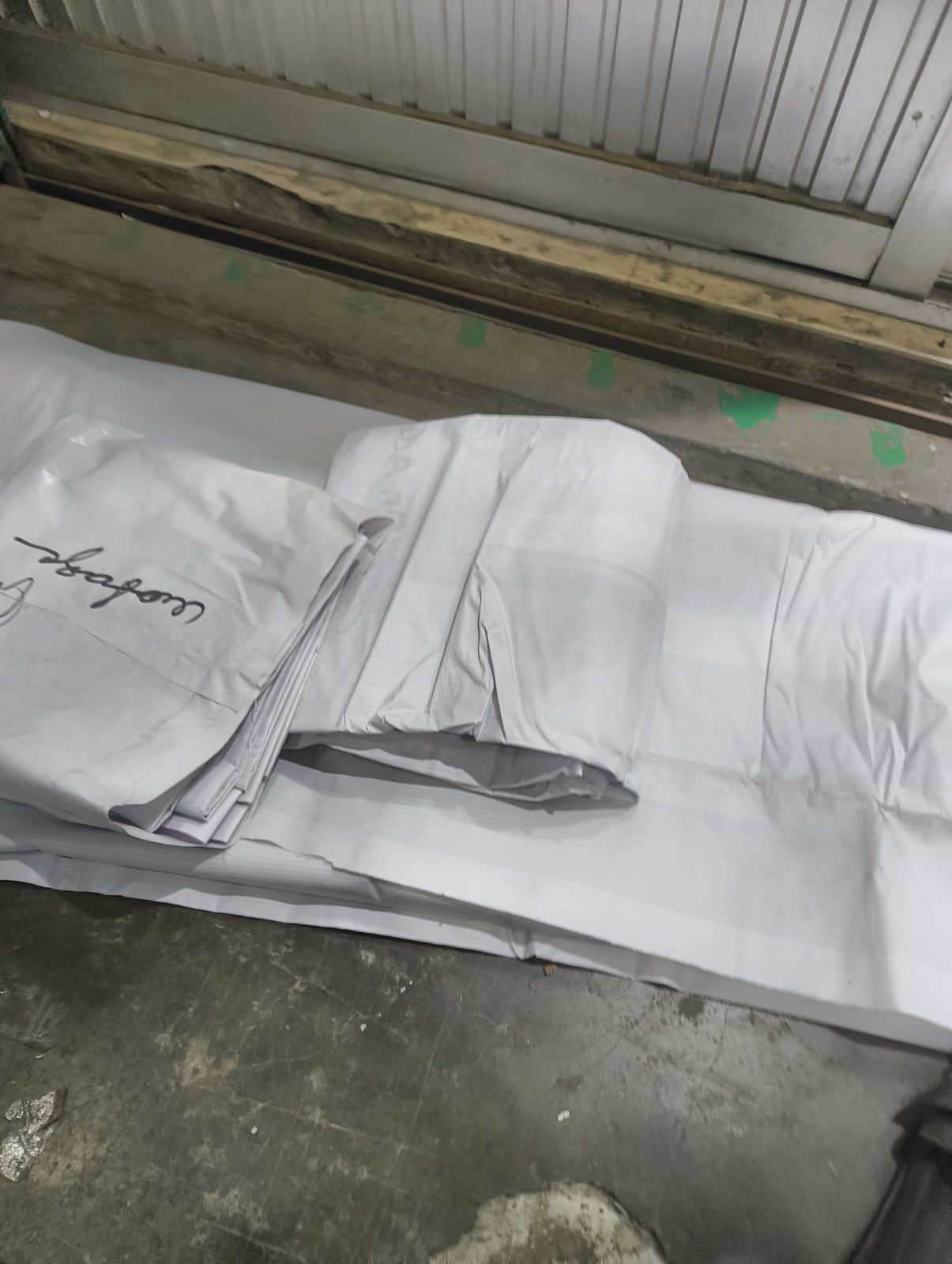 Discarded white banners folded outside a printing shop