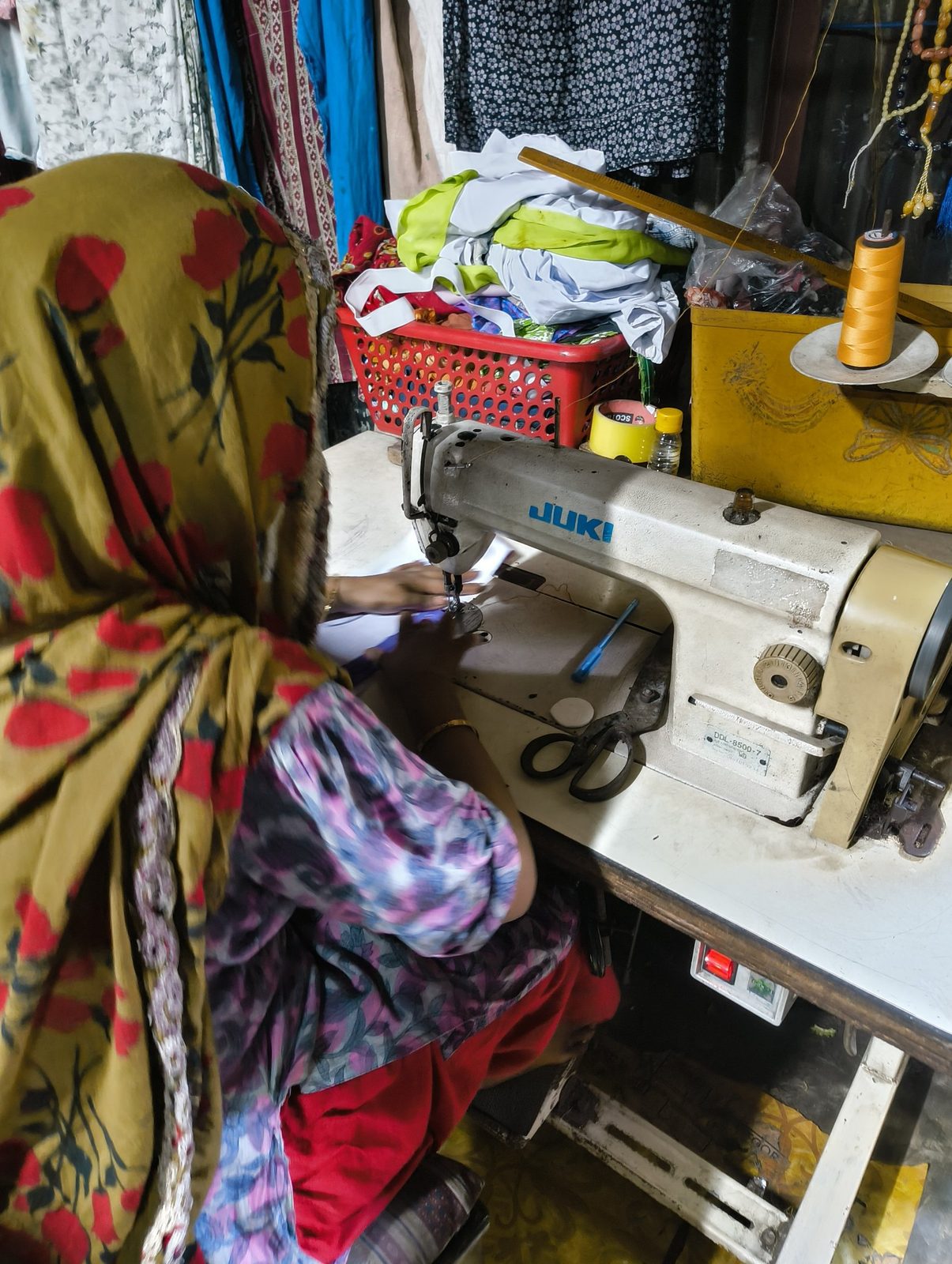 An artisan stitching banner material on an industrial sewing machine